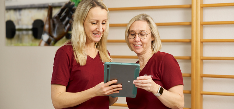 Team im Austausch über Therapie und digitale Dokumentation in Physiopraxis Paderborn.