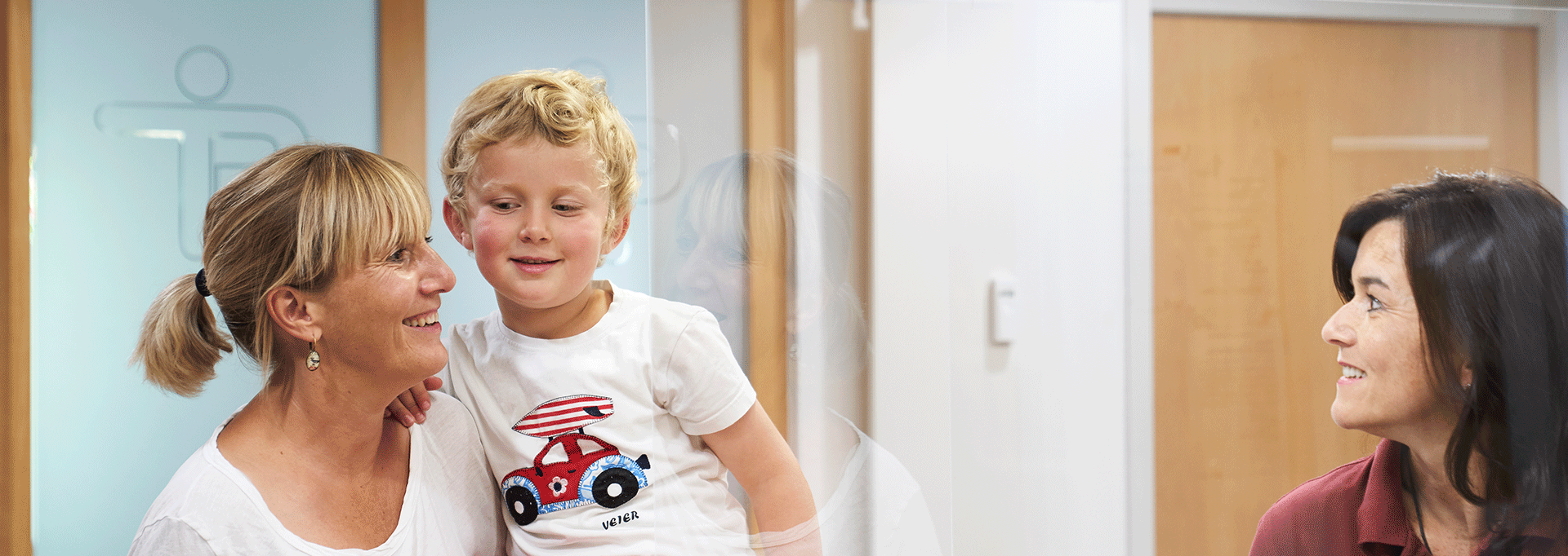 Freundliche Begrüßung in der Physiotherapiepraxis Paderborn zwischen der Verwaltungsfachkraft und Patienten