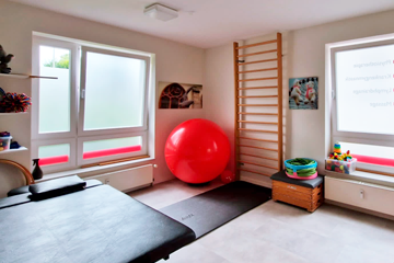 Behandlungsraum in einer Physiotherapiepraxis mit Therapieliege, Bobath-Ball, Sprossenwand und anderen Trainingsmaterialien