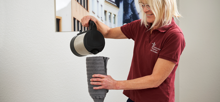 Anwendung der heißen Rolle zur Vorbereitung auf die Physiotherapie Behandlung