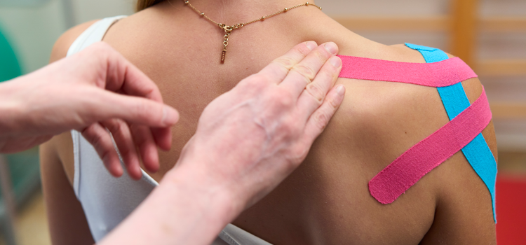 Kinesiotaping in der Physiotherapie, Therapeut bringt Tape bei Patient an